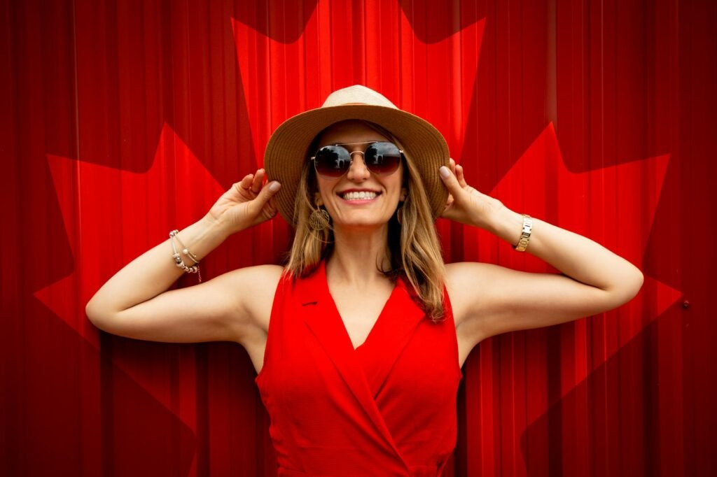 woman in red sleeveless dress with canada flag printed background